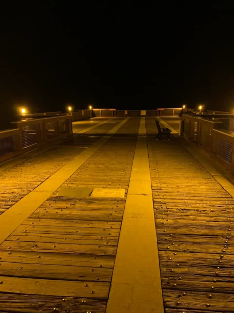 Close view of pier deck and rail lighting after dark at Casino Beach