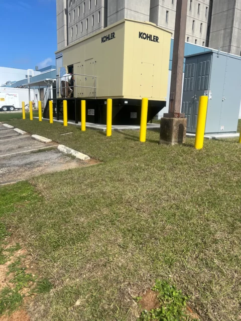 Finished Kohler standby generator protected by yellow bollards