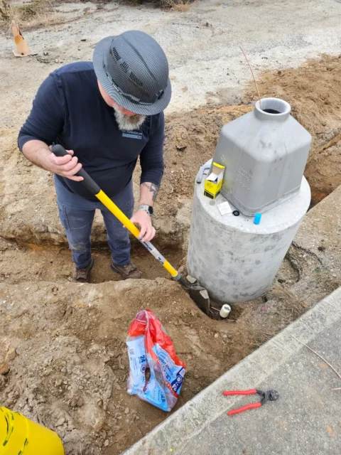 Electrician preparing conductors at a new light pole foundation
