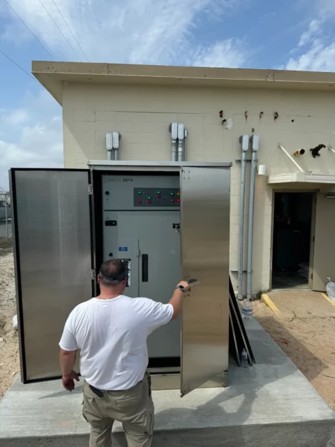 Electrician opening an outdoor stainless switchgear enclosure