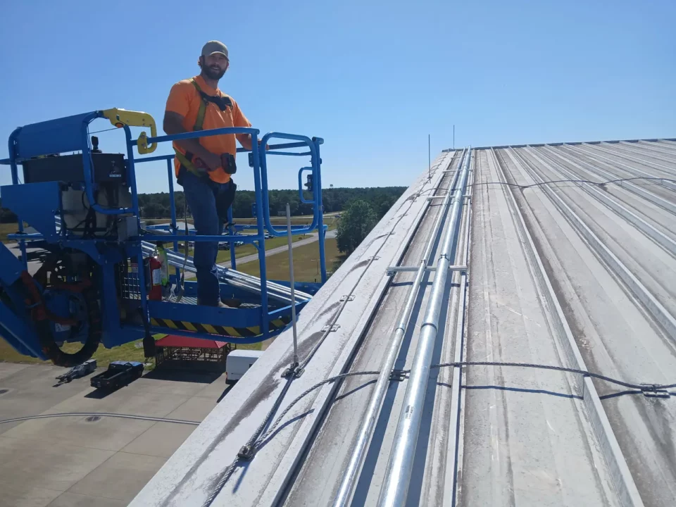 Electrician on a boom lift at the end of a long rooftop conduit run